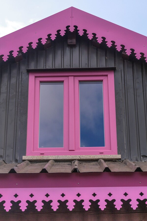 A building with a pink window and a pink roof.