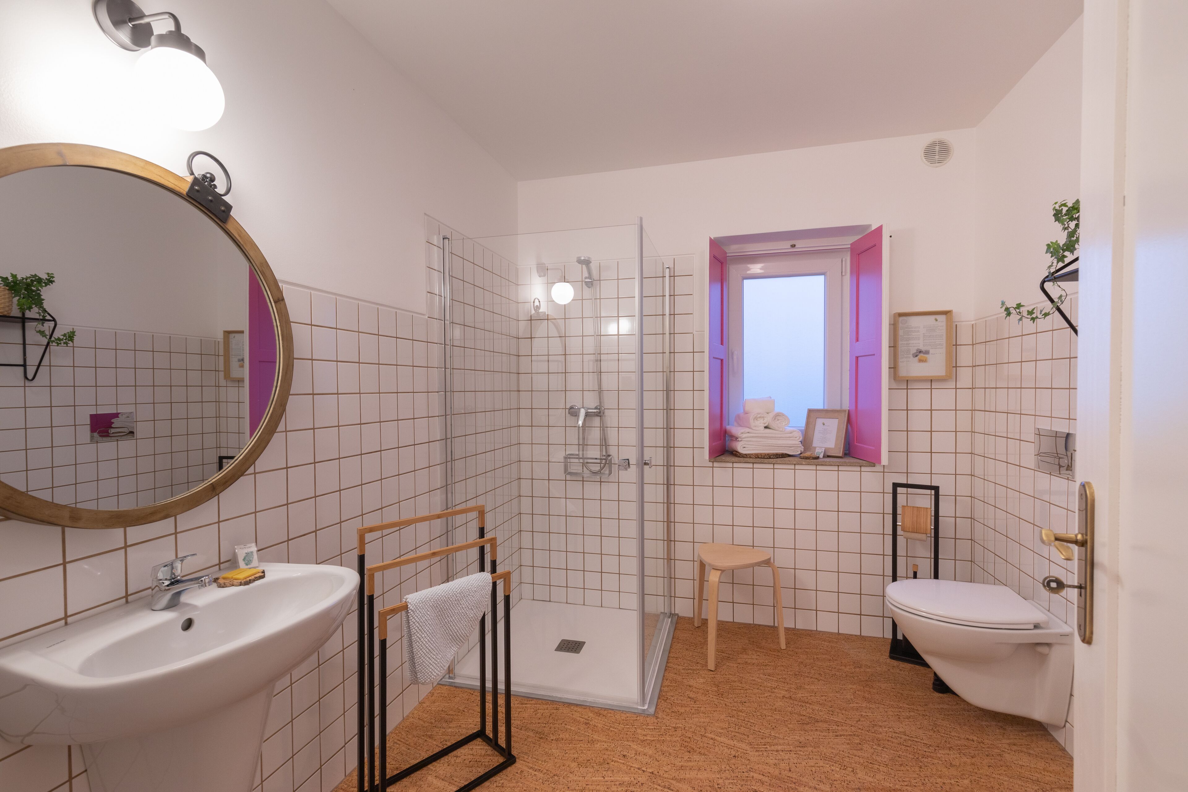 Une salle de bain équipée d’un lavabo, d’un miroir, d’une douche et de toilettes.