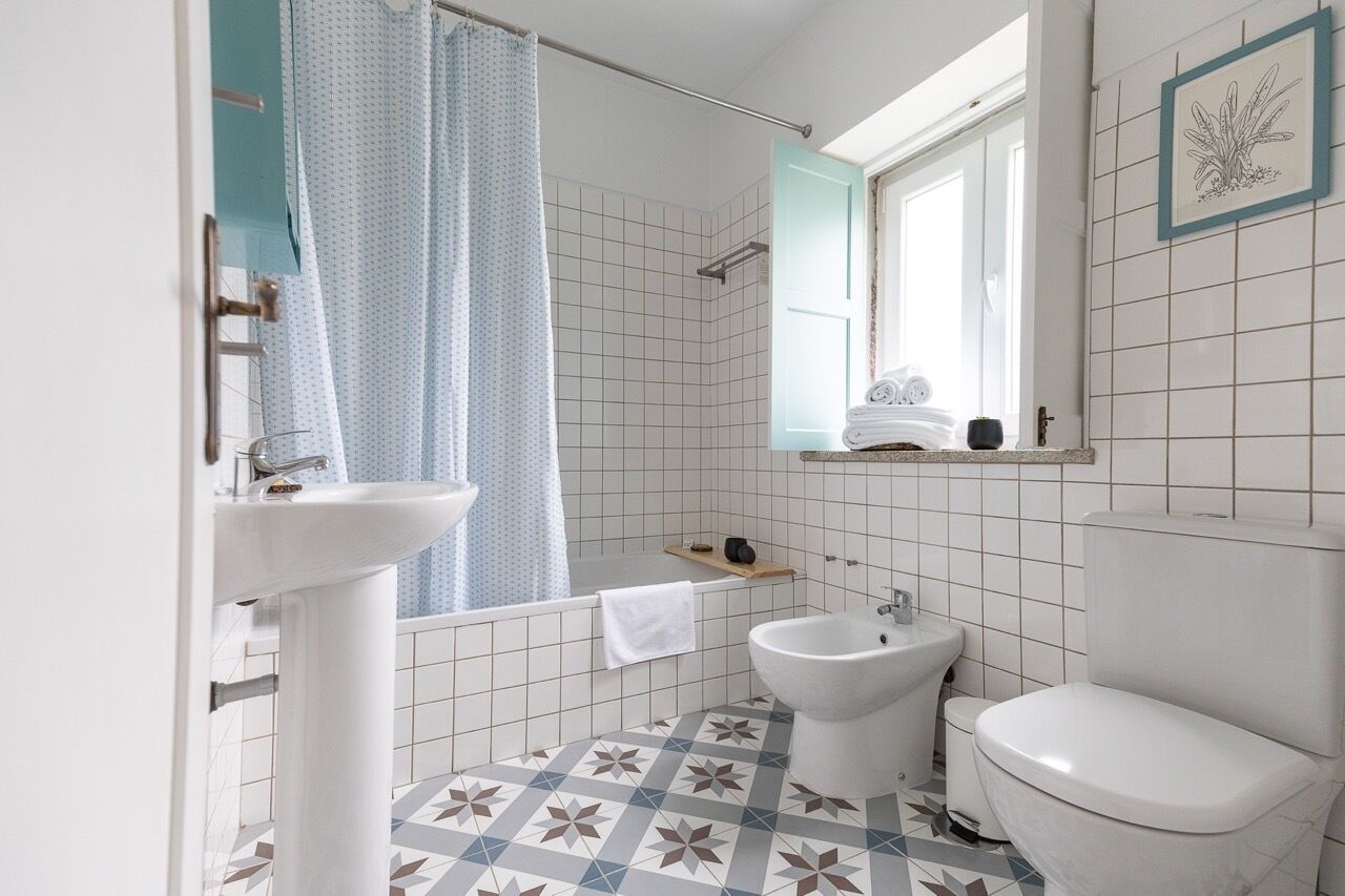 Un baño con lavamanos, bidé, inodoro y zona de ducha.