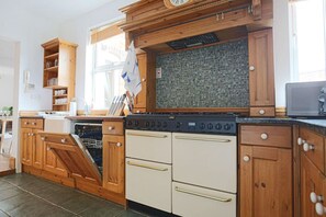 A kitchen with wooden cabinets, a stove, and a dishwasher.