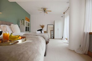 A bedroom with two beds, a ceiling fan, a wardrobe, and a bedside table with a tray of fruit and juice. - Central House • Sleeps 9 • FreeParking • Pool Table • Fast Wifi • Balcony • VirginTV • Yoko Property (Northampton)