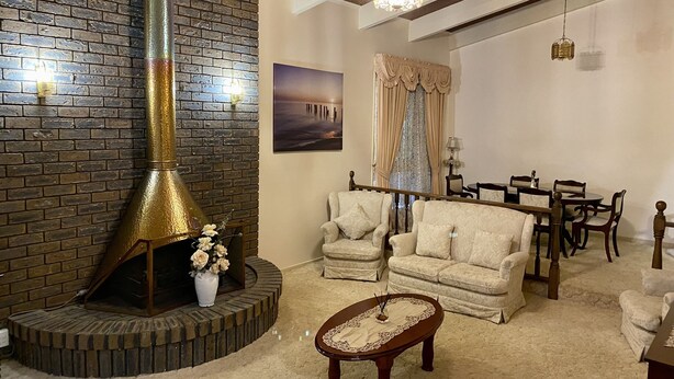 A cozy living room with a brick fireplace, comfortable seating, and a dining area.