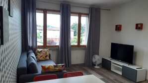 Un salon moderne avec un canapé, une table à manger et un téléviseur.