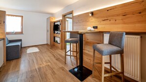 A modern kitchen with wooden accents, a dining area with bar stools, and a cozy seating area.
