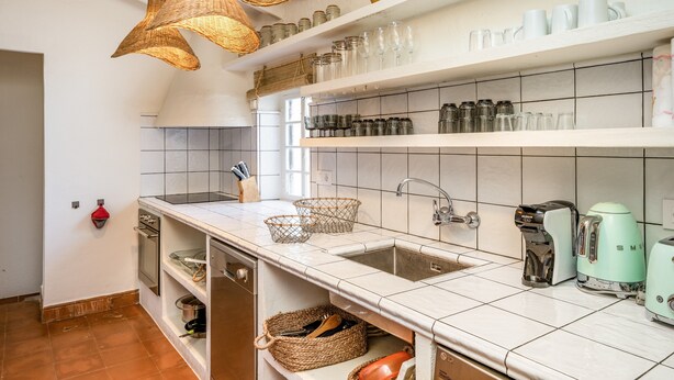 A kitchen with white tiles, a sink, a toaster, and wicker baskets. - Villa Torret with workspace, pool, terrace, and Wi-Fi (Sant Lluis)