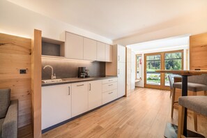 Eine moderne Küche mit Holzausstattung, einem Einbauherd und einem Essbereich mit Tisch und Stühlen.