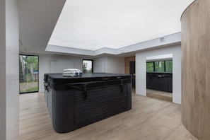 Una habitación moderna con un mueble de almacenaje negro grande, una pared de acento de madera y vistas al exterior.