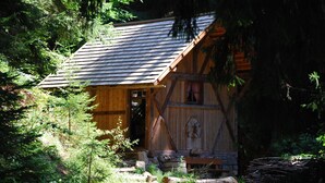 A rustic cabin with a sloped roof, wooden walls, and a small porch. - Eichernhof Apartment Marillenblüte – Delicious Vital Breakfast and Dinner Available on Request (Verano)