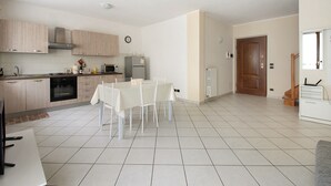 Una cocina moderna con comedor, horno empotrado, microondas y refrigerador.