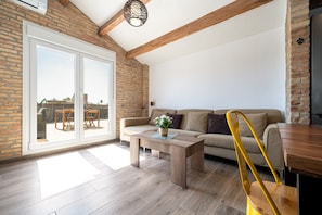 A modern living room with a wooden floor, a sofa, a coffee table, and a yellow chair.