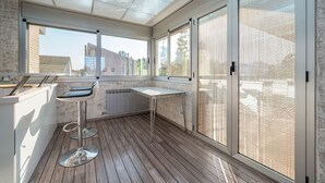 A modern kitchen with a wooden floor, a white countertop, and a bar stool. - Villa 'Luxury Rock Tirri' with Private Pool, Covered Terrace, and Wi-Fi (Reus)