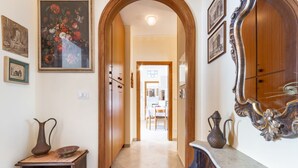 A hallway with a wooden door, a marble counter, and a mirror. - GuestHost - Bella Vista Apartment with balcony SEA VIEW (Otranto)