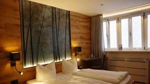 A hotel room with a large bed, two bedside tables, a desk, and a window with curtains. - Hotelgasthof Bayerischer Hof (Sulzbach-Rosenberg)