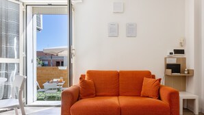 Une pièce lumineuse avec un canapé, une table et des chaises.