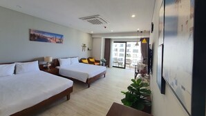 Habitación de hotel con dos camas, un balcón y un ventanal grande.