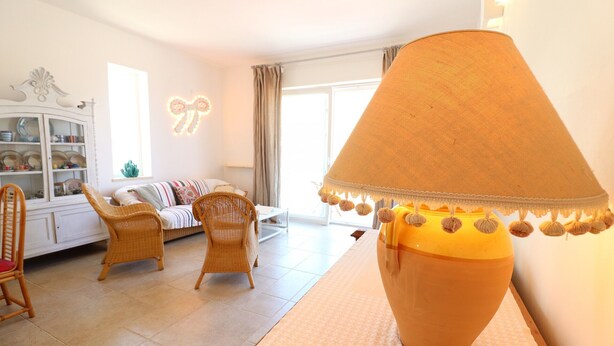 A living room with a sofa, chairs, a lamp, and a cabinet. - Casa Paola Otranto Apartment with Sea View, Balcony and Air Conditioning (otranto)