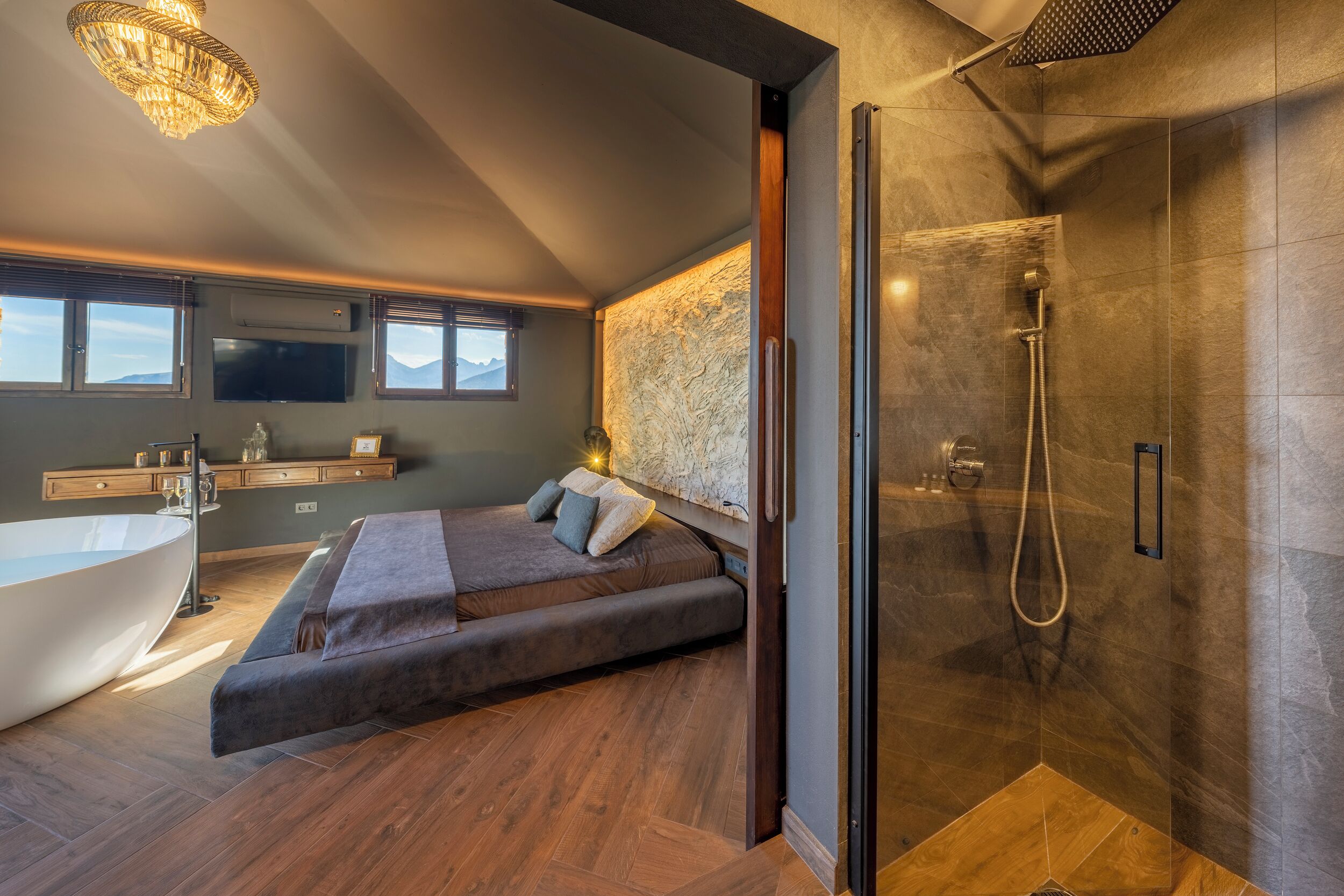 A modern bathroom with a bathtub, shower, and a large mirror.