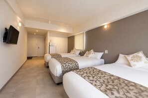 A hotel room with three beds, a television, a refrigerator, and a door leading to another room. - Mr.KINJO GRAND CATS (Ishigaki)