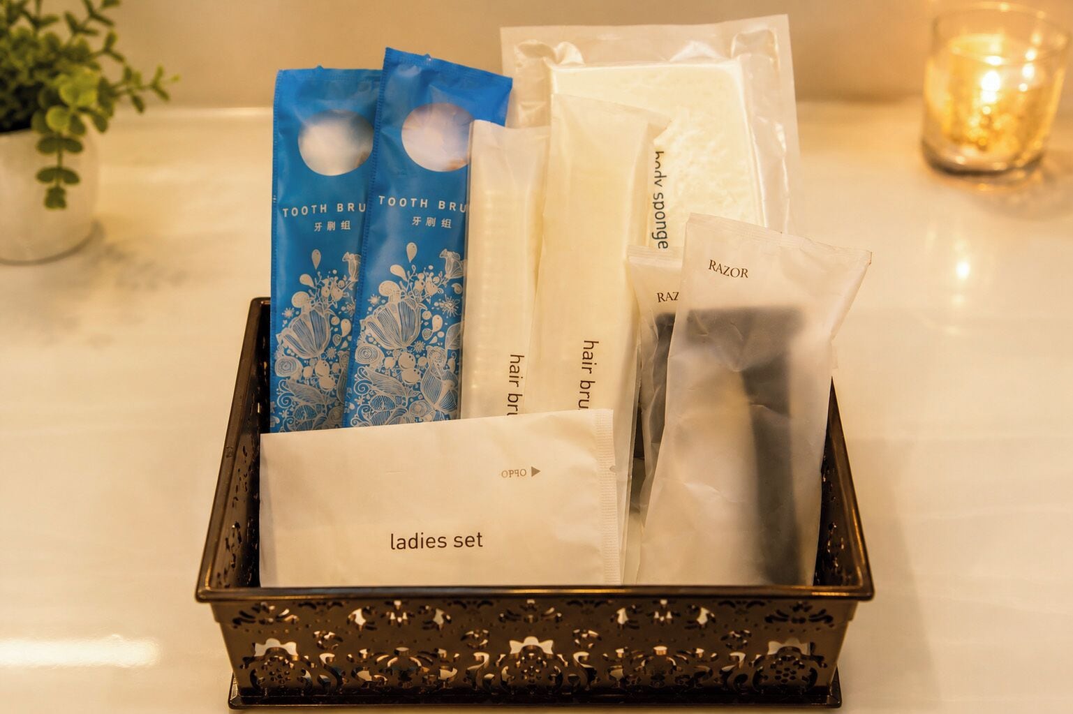 A tray with a ladies set including a toothbrush, hair brush, razor, and sponge.