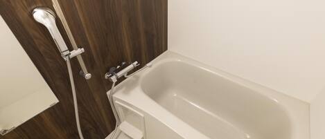 Un baño con puerta de madera, una bañera blanca y zona de ducha.