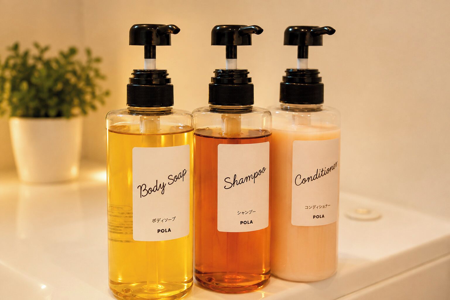Trois bouteilles contenant un liquide, posées sur une surface blanche.