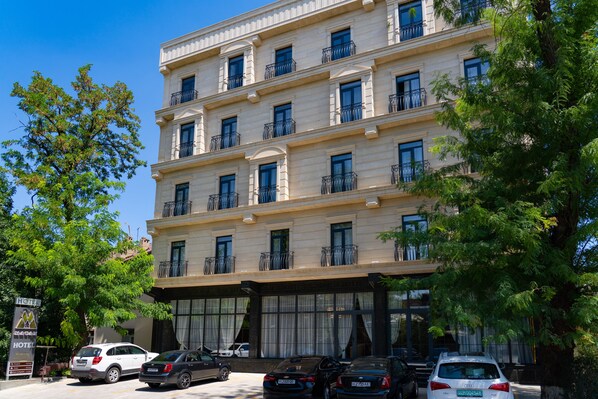 A multi-story hotel with a classic architectural style, featuring balconies on each floor.