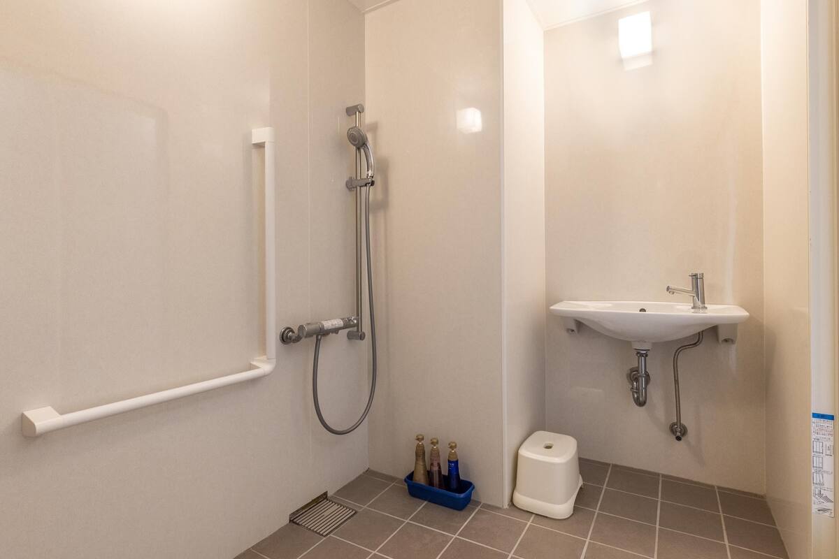 A bathroom with a shower, sink, and toilet.