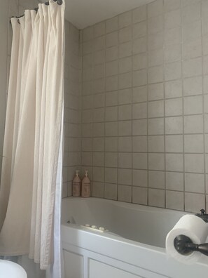 Bañera, secador de pelo, toallas y jabón