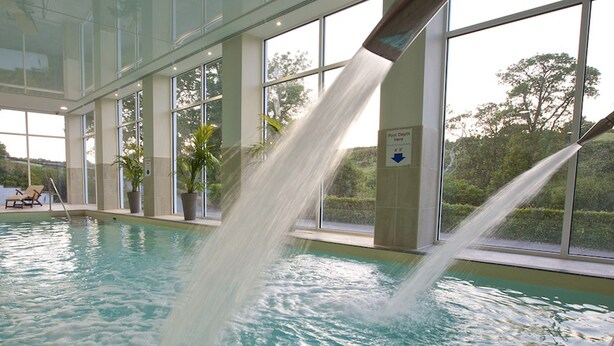 An indoor swimming pool with clear water, large windows, and a sign indicating pool depth. - Kestrel, 19 Dartmouth Green (Totnes)