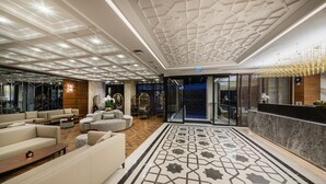 Um hall moderno com piso estampado, área de estar e balcão de recepção.