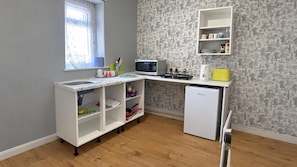 A compact kitchenette with a microwave, toaster, and refrigerator.