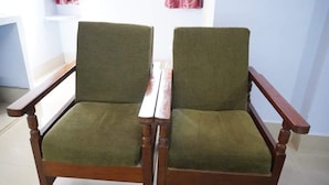 Dos sillones de madera con tapicería verde.