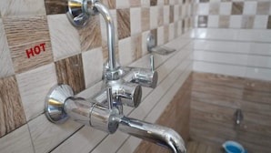 Un baño con grifo de cromo y salpicadero de azulejos a cuadros.