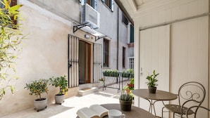 An outdoor seating area with a table, chairs, and a potted plant.