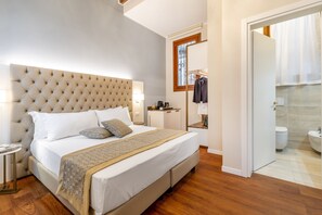 Une chambre avec un grand lit, une table de chevet, un miroir et une vue sur la salle de bain.