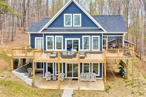 Relax on the covered deck with seating, surrounded by a serene natural landscape.