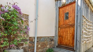 A rustic wooden door with a stone wall and a sign reading "Periwinkle".