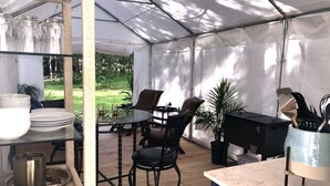 A tented outdoor area with a table, chairs, and a bar. - Glamping in the Captain’s Quarters! (Wendover)