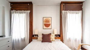 A neatly arranged bedroom with a bed, two bedside tables, a chair, and a framed artwork on the wall. - Ciel Apartment, Wifi, Balcony !new! (Tróia)