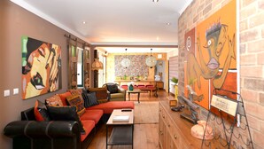 Un salon moderne avec un canapé, une table basse et des œuvres d’art accrochées aux murs.