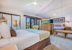 A bedroom with a bed, a TV, a desk, and a chair.