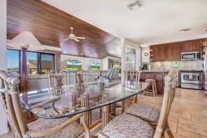 A modern kitchen with wooden cabinets, a stainless steel microwave, and an oven. - Oceanfront Gem with Mesmerizing Views and Lush Surroundings – Wailea Elua #1404 (Wailea, Maui)