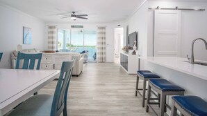 A modern kitchen with a dining area, a view to the outside, and a ceiling fan. - Coco Cay House on Coco Plum with pool and dock (Marathon)