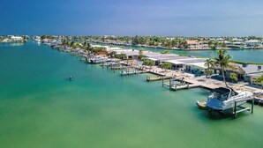 An aerial view of a marina with docks, boats, and buildings along the waterfront. - Sea La Vie 2 bedroom on open water in Kcb (Key Colony Beach)