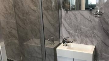 Een douche, handdoeken, toiletpapier