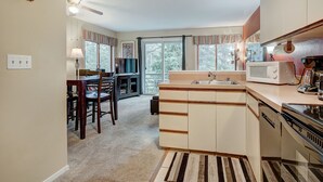 A compact kitchen with a dining area, a microwave, a coffee maker, and a view of the outdoors. - Ski-In/Ski-Out from this Condo with Shared Hot Tub & Sauna Acces (Breckenridge)