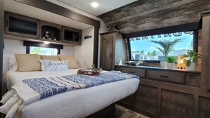 A bedroom with a bed, a window, and wooden cabinetry. - Hidden gem in Key Largo, bunk room, outdoor kitchen, 2 pools, laundry, 2 beaches (Key Largo)
