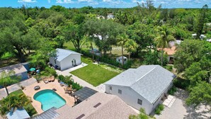 Un quartier résidentiel doté d’une piscine, d’une maison avec un toit en pente et d’un environnement verdoyant.
