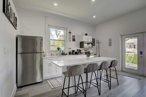 Una cocina moderna con una isla grande, electrodomésticos de acero inoxidable y vistas al exterior.