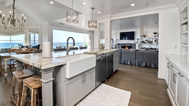 Un'ampia cucina con un'isola grande, elettrodomestici moderni e vista all'esterno.